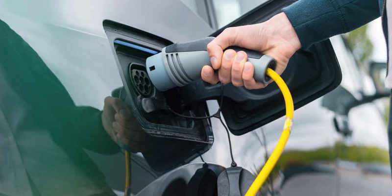 Hand som ansluter laddkabel till laddstation i Mariestad
