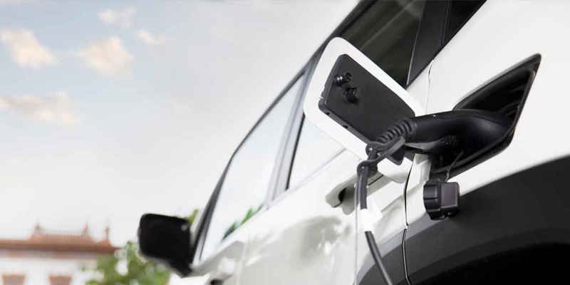 Elbil laddas vid laddstation i Borås med bakgrund av stadsmiljö