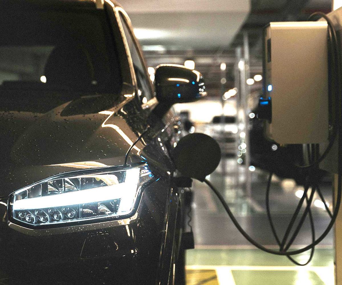 Elbil laddas i underjordiskt garage med väggmonterad laddare