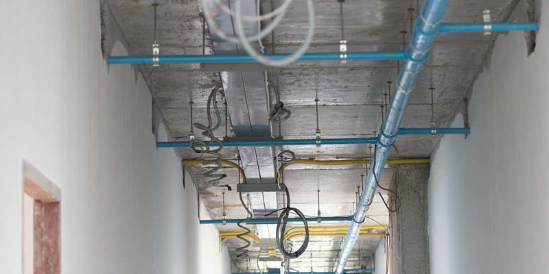 Exponerad byggnadsinfrastruktur med rör och ledningar.