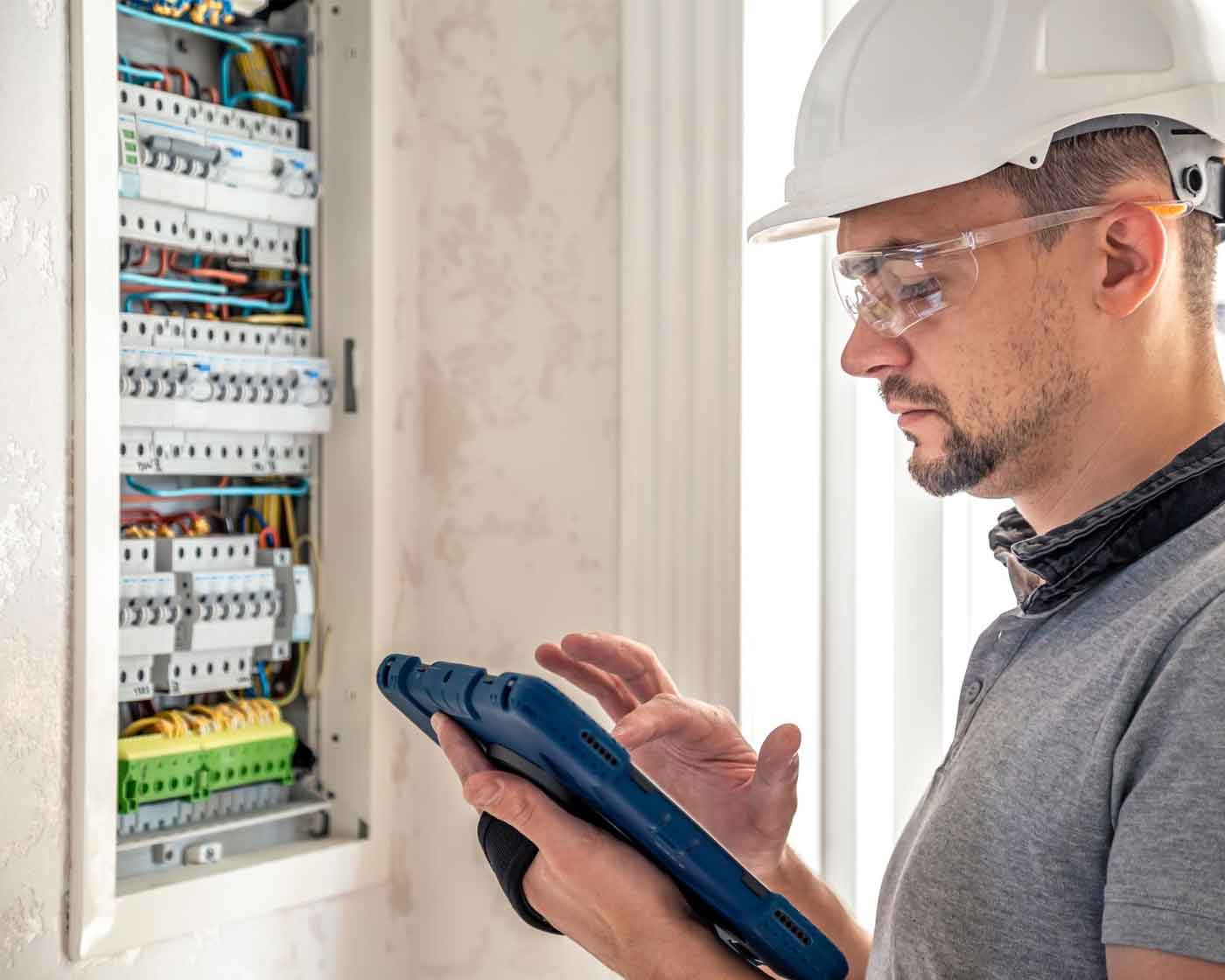 Elektriker kontrollerar elcentral i flerbostadshus