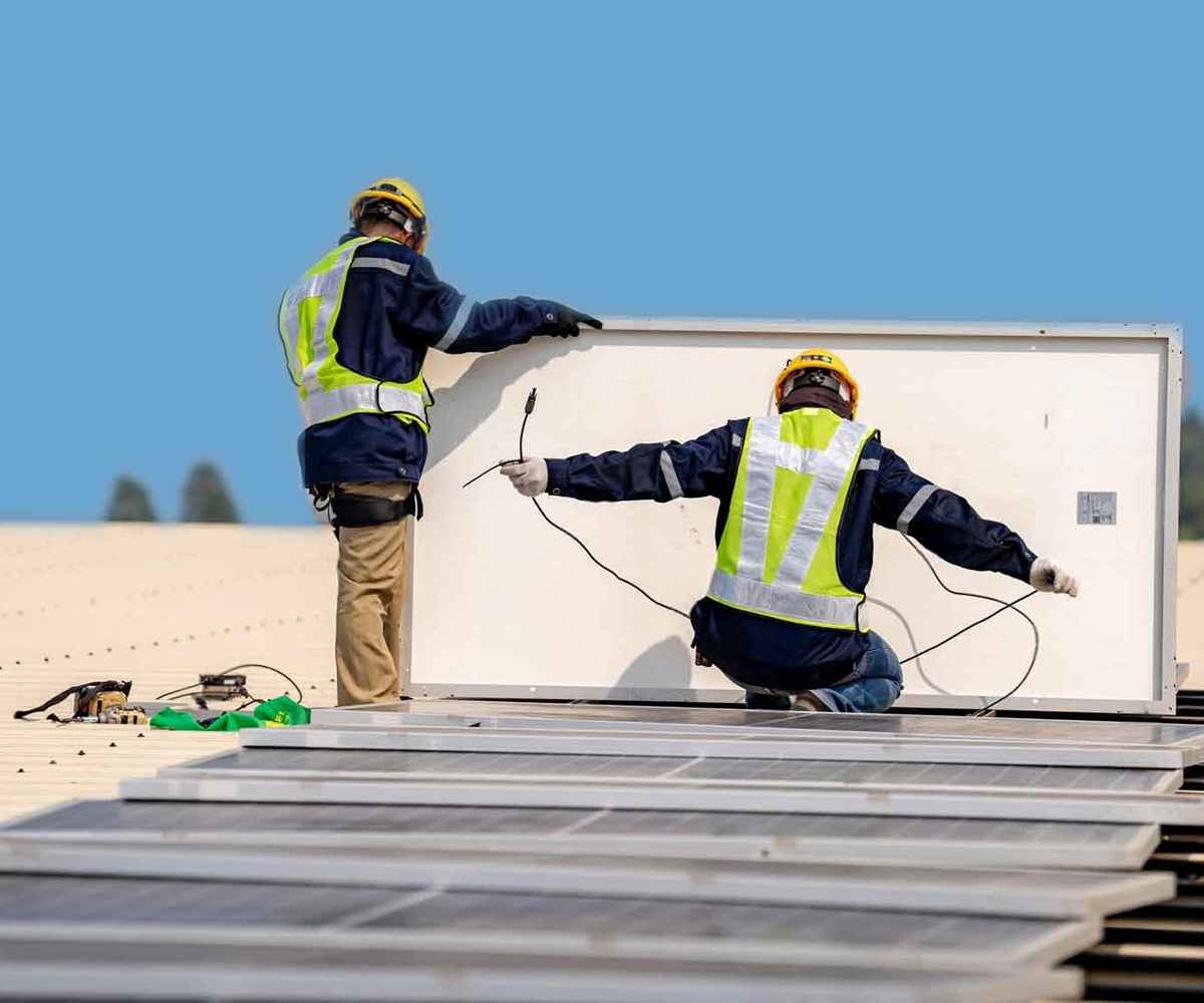 Närbild av installation av solpaneler med verktyg och montör