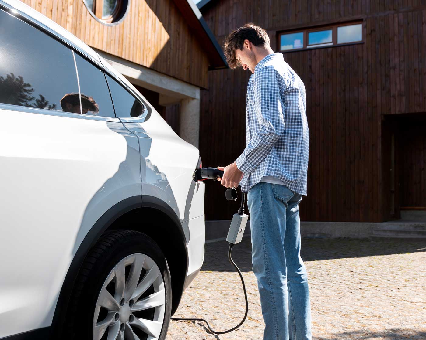 Elbil som laddas vid publik laddstolpe i bostadsområde