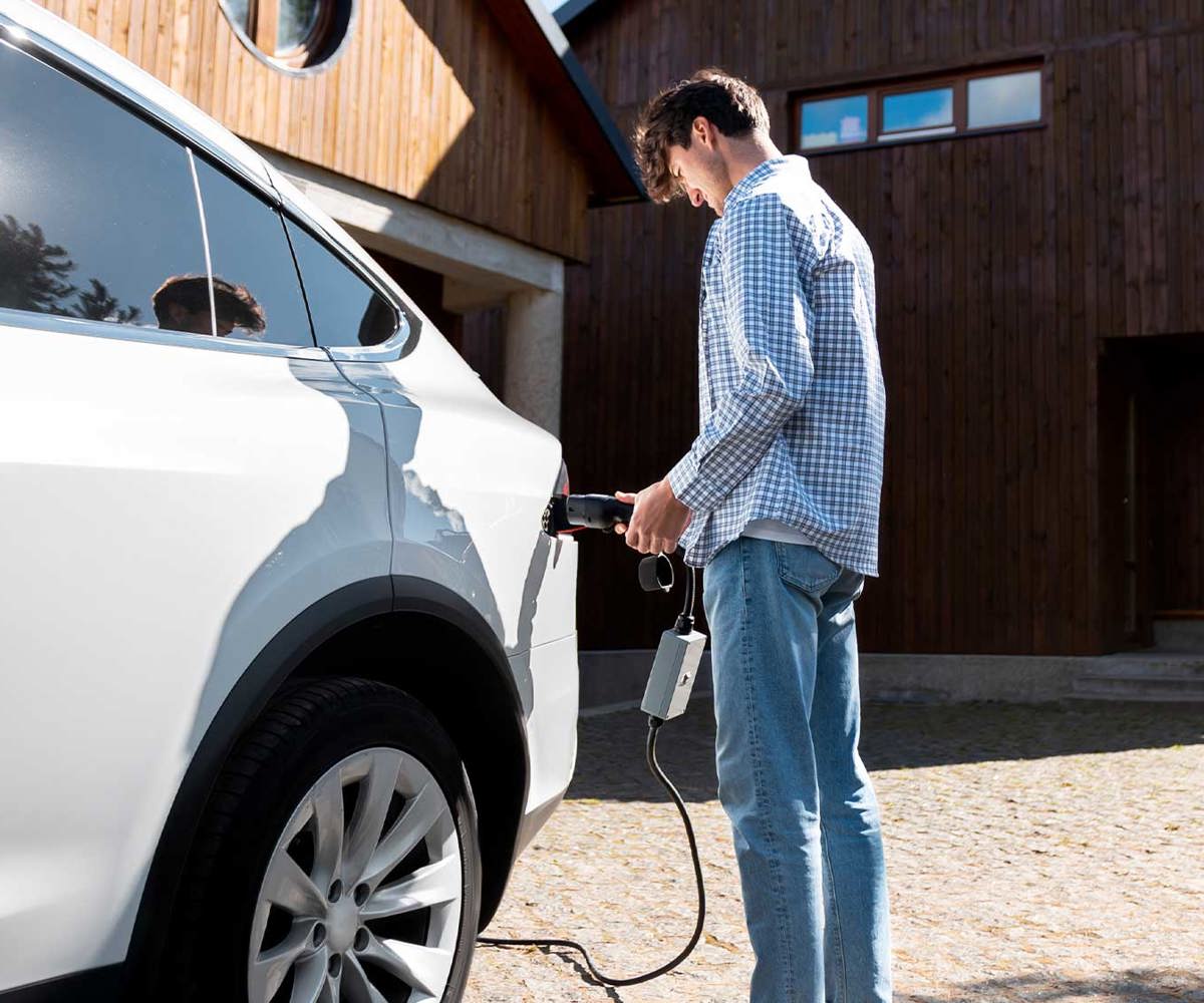 Elbil som laddas vid publik laddstolpe i bostadsområde